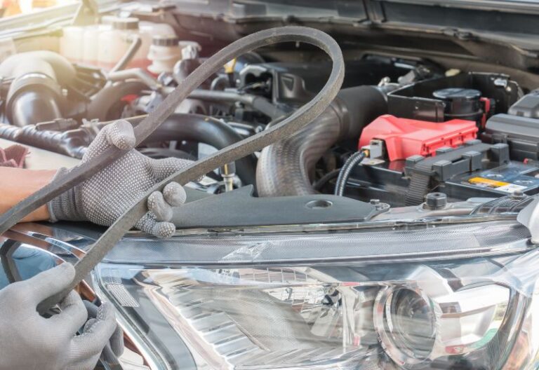 Auto repair technician servicing engine belts and hoses in Central Minnesota